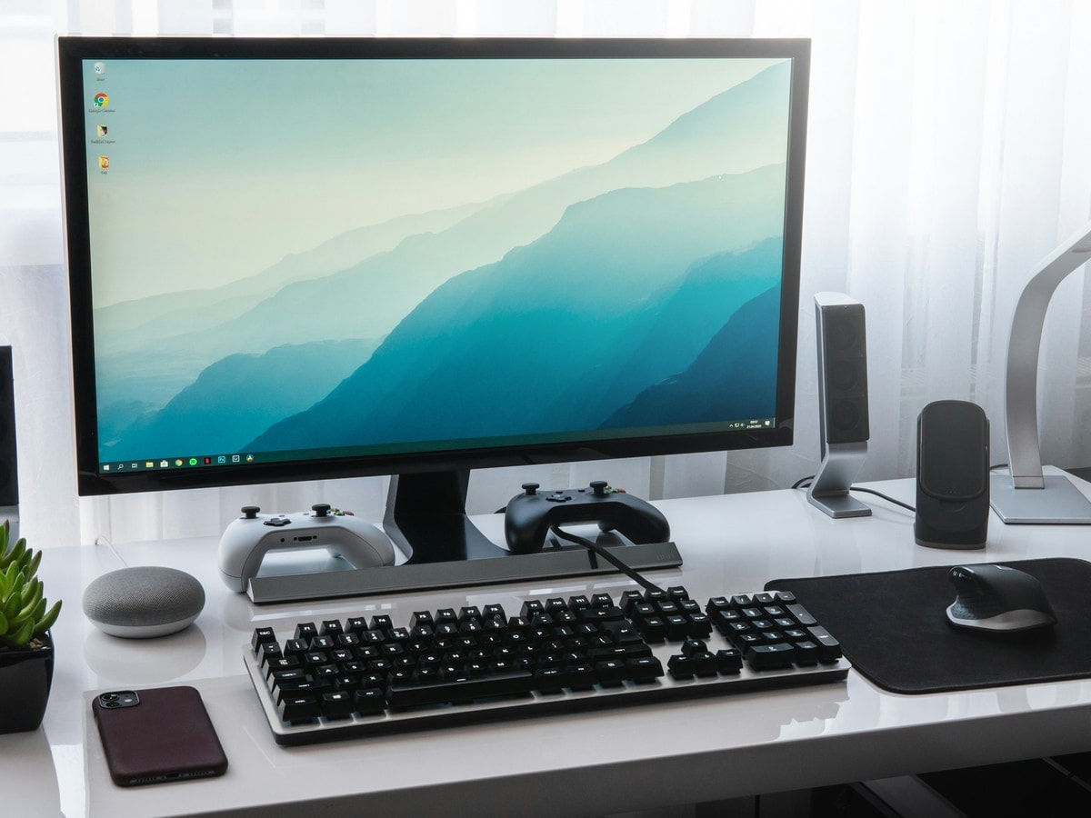 A desk with a monitor, keyboard and peripherals plugged in