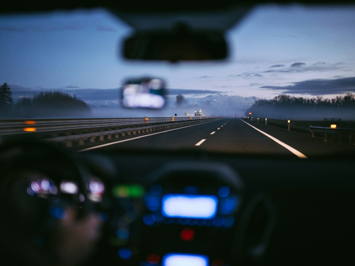 The view forward from inside a car on a highway at dusk